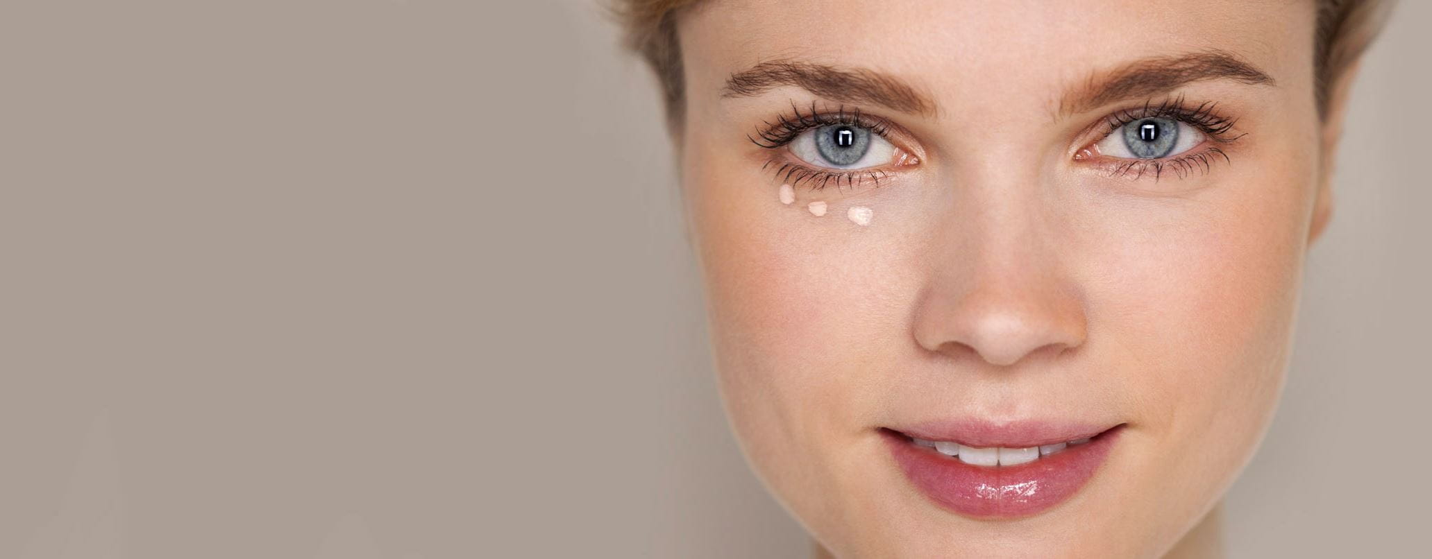 Frau mit Concealerpunkten unter einem Auge