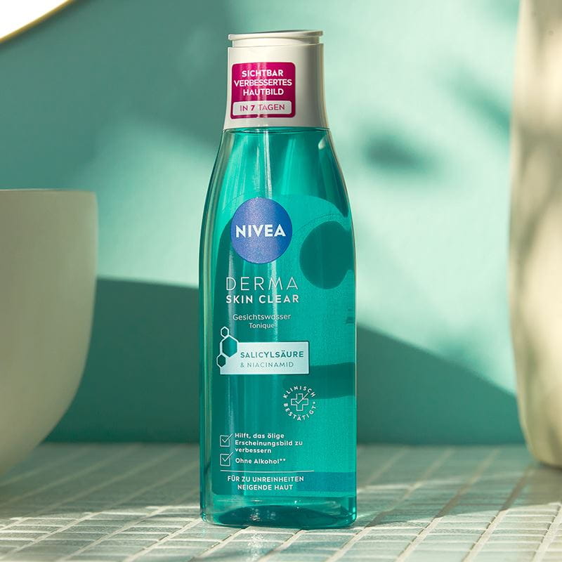 Nivea Skin Clear Gesichtswasser steht auf einem gefliesten Badezimmertisch neben einem Waschbecken.