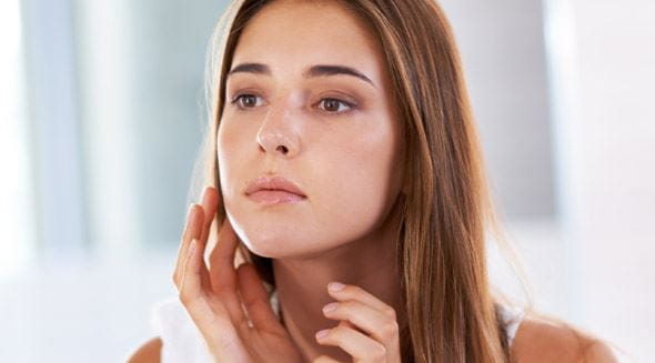 Femme se caresse le visage