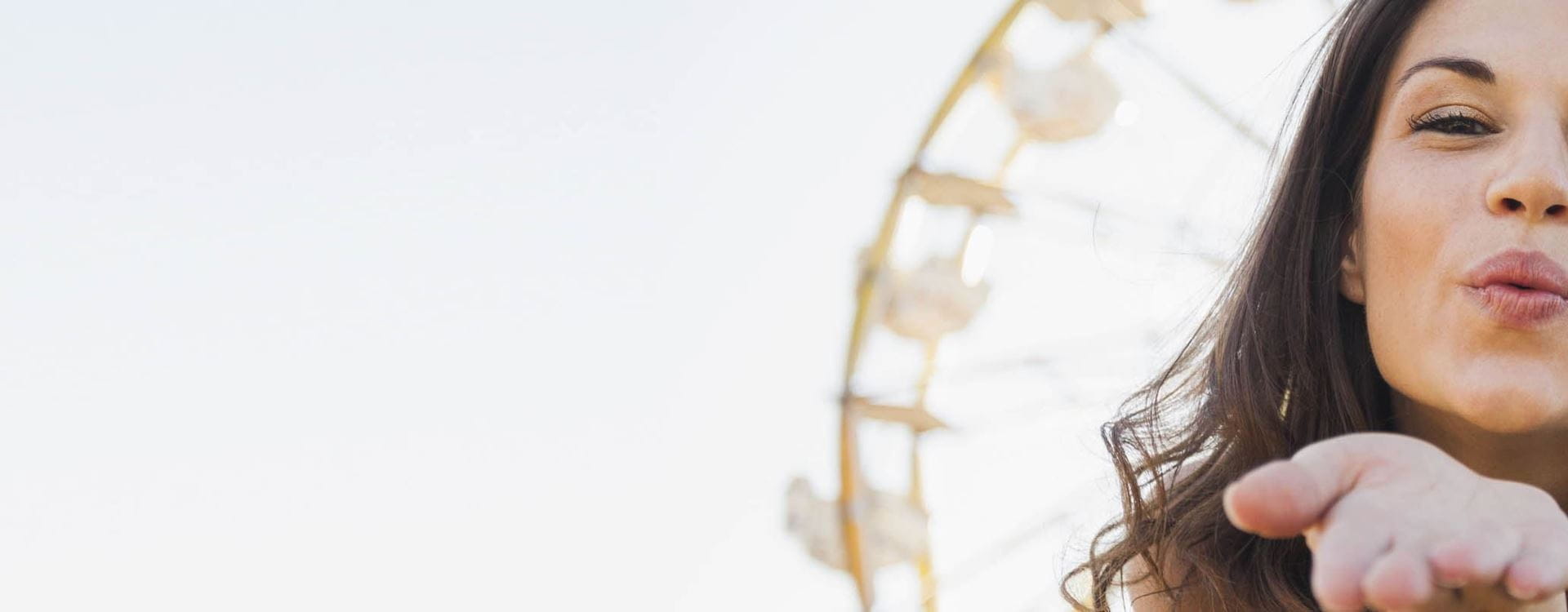 Frau macht Kussmund und hält sich die Augen zu