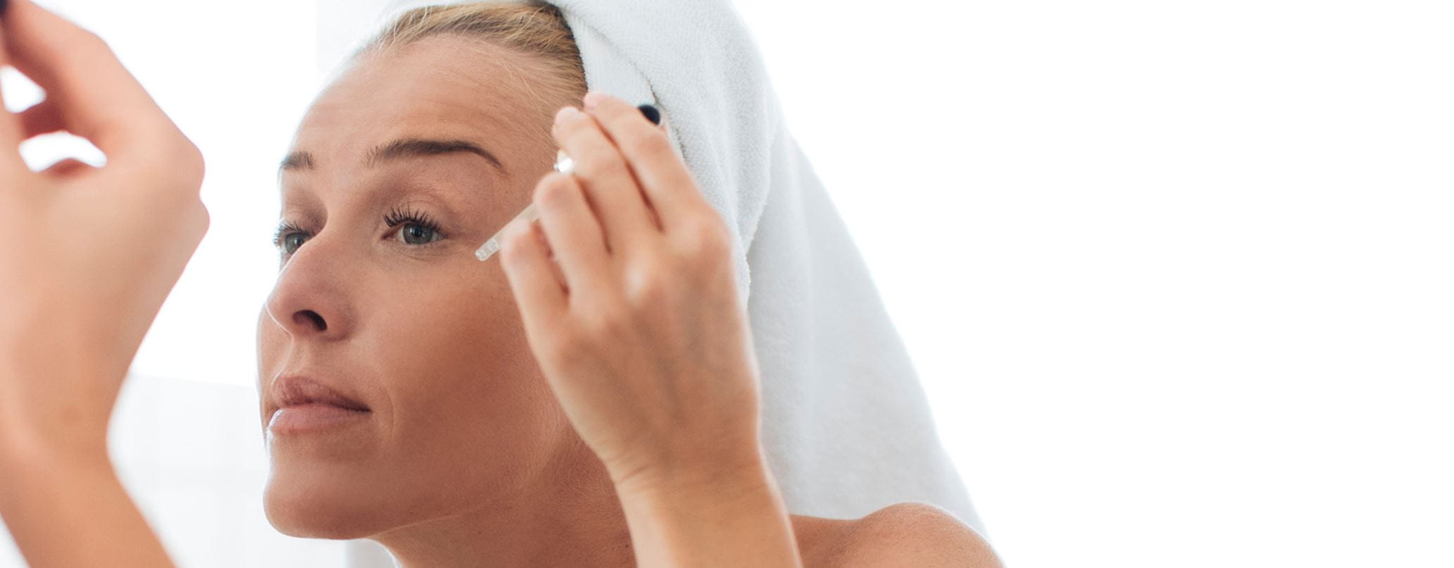 Frau trägt Gesichtsöl auf