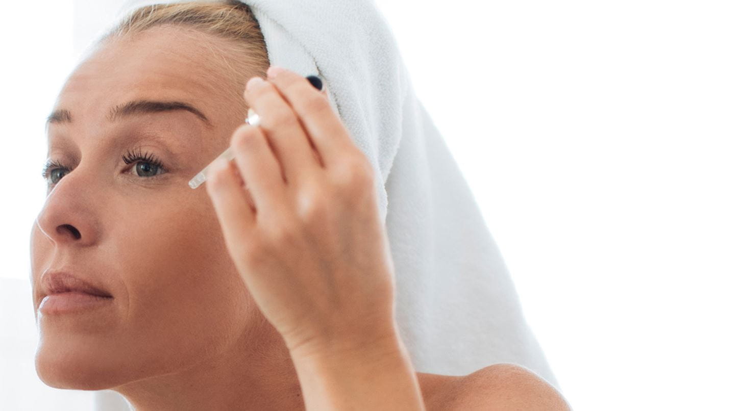 Frau trägt Gesichtsöl auf