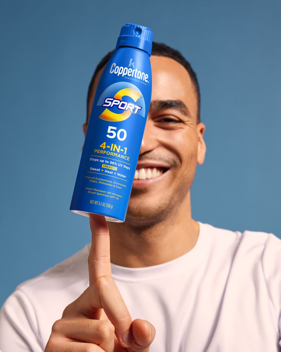 man balancing coppertone sport sunscreen spray on his finger