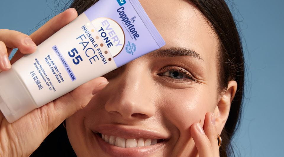 woman smiling holding sunscreen