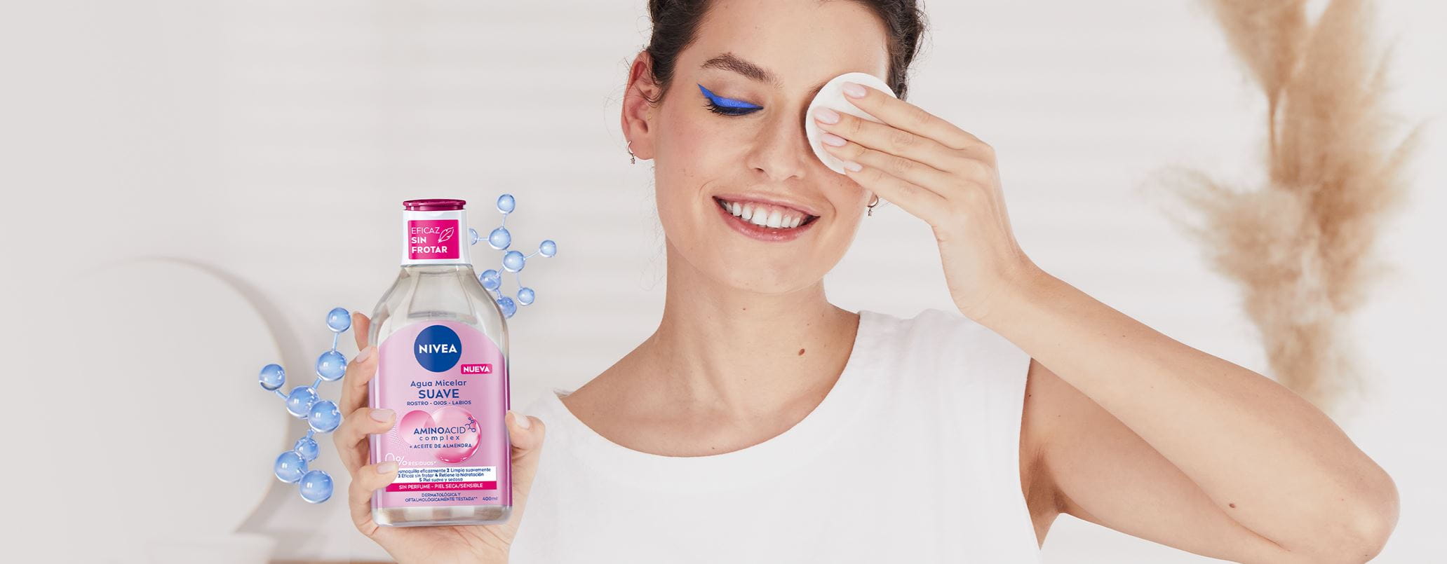 Una mujer se ha desmaquillado los ojos con la NUEVA Agua Micelar NIVEA y muestra el disco de algodón.