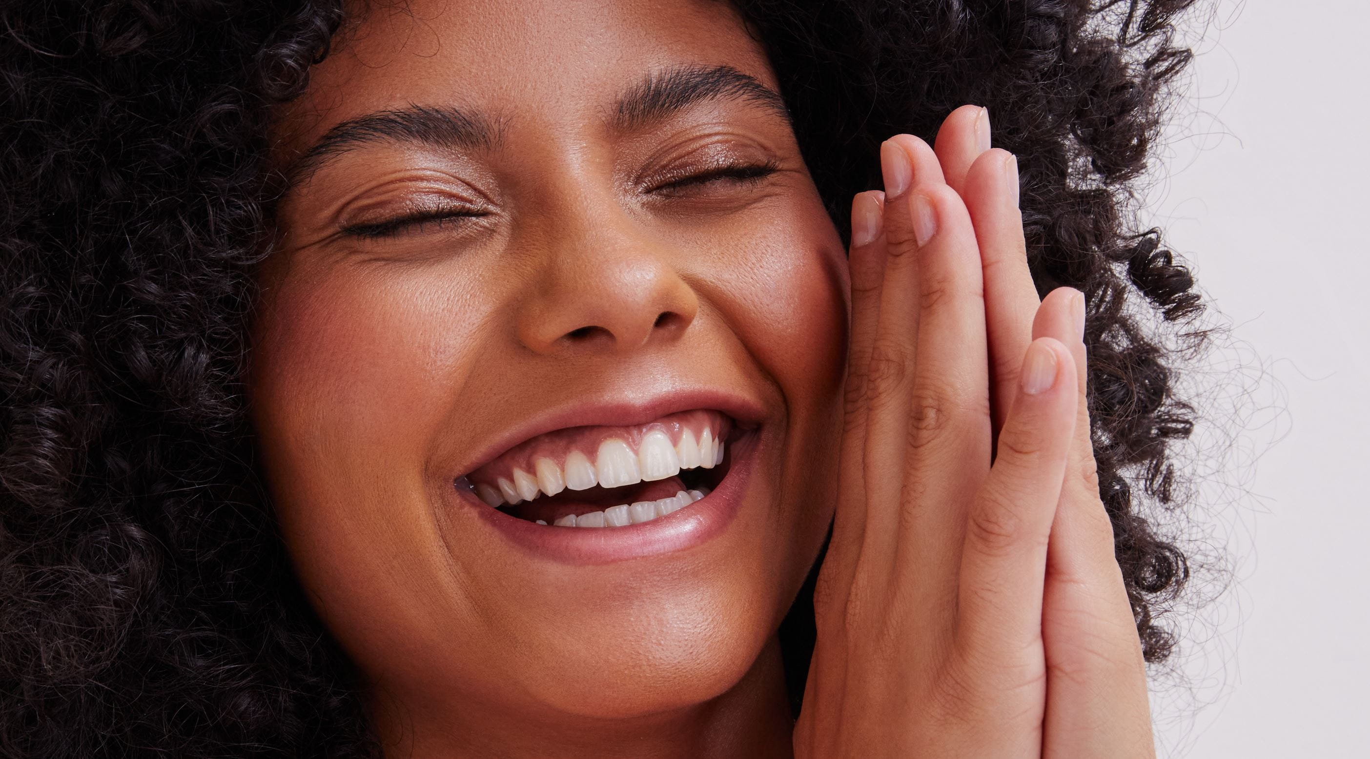 Fille aux cheveux bouclés tenant une crème pour les mains Nivea