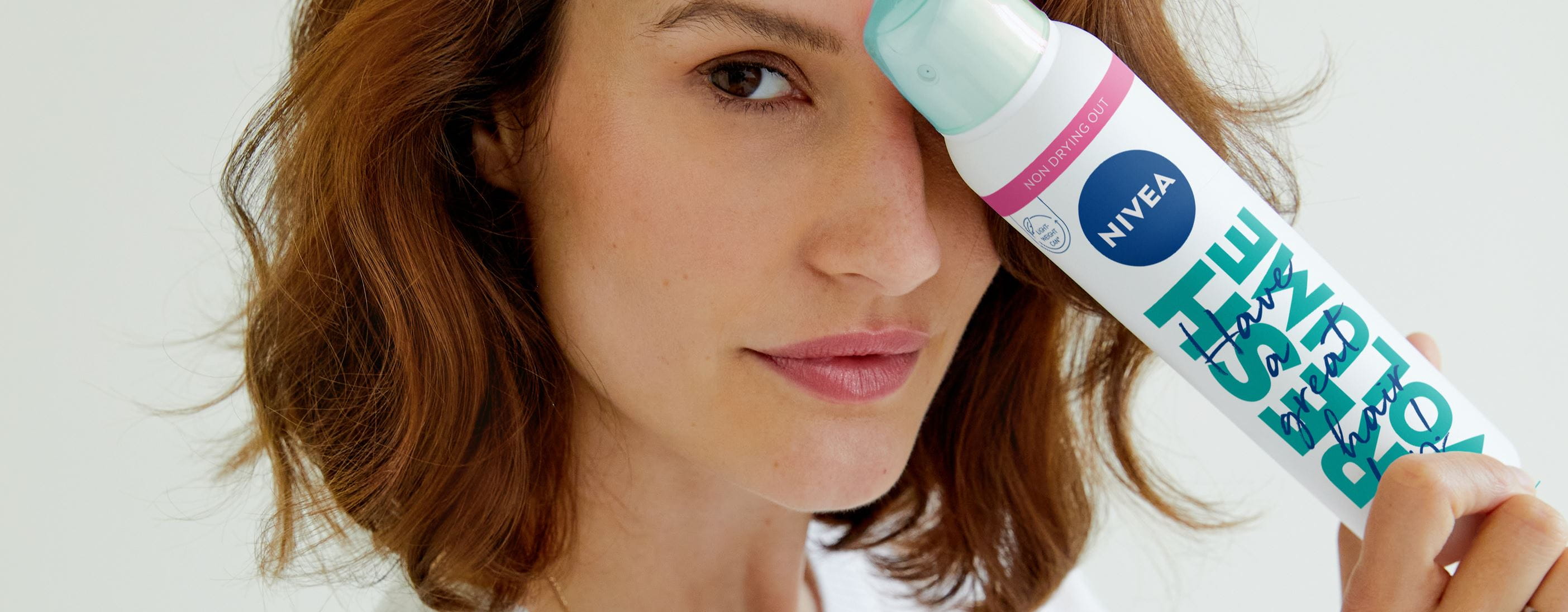 Junge Frau benutzt Trockenshampoo von Nivea