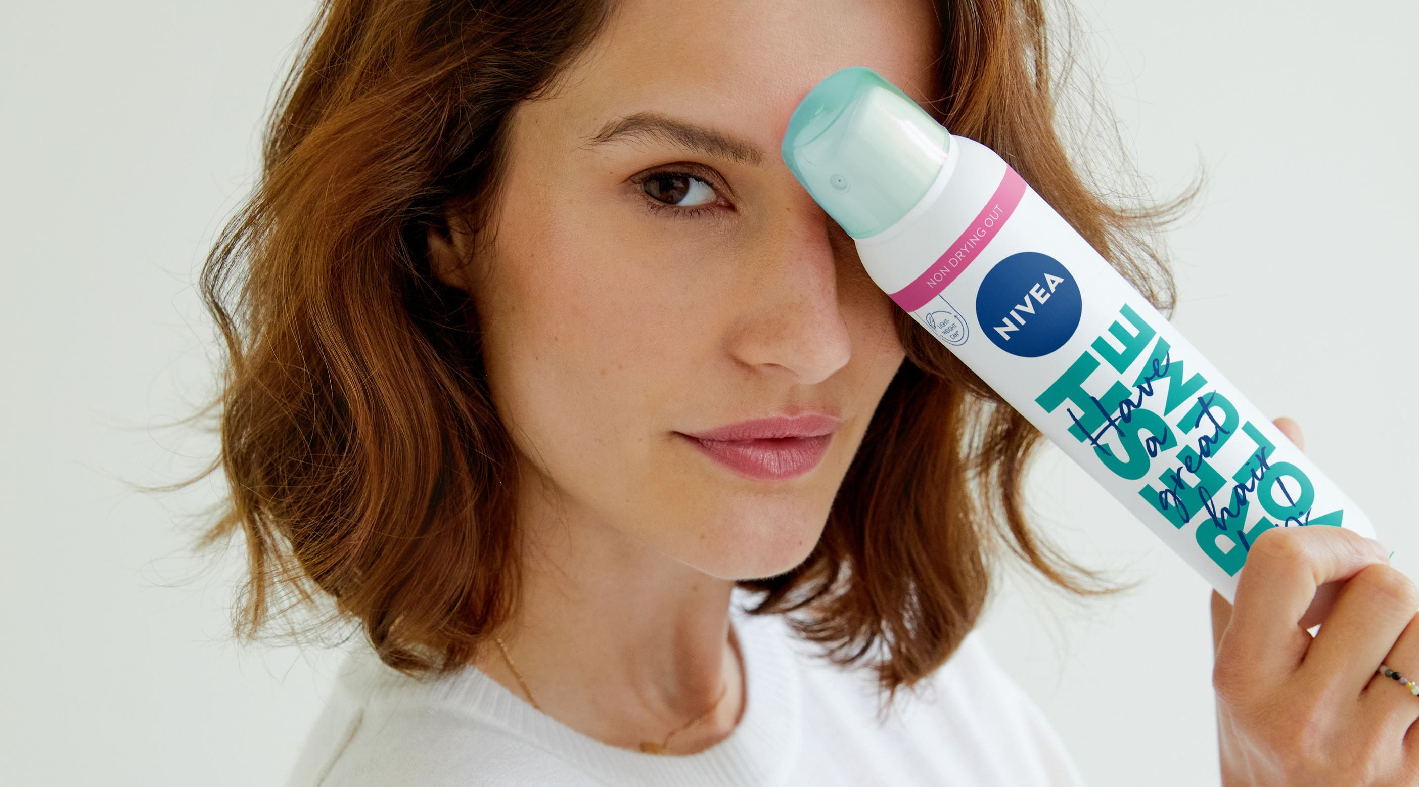 Junge Frau benutzt Trockenshampoo von Nivea