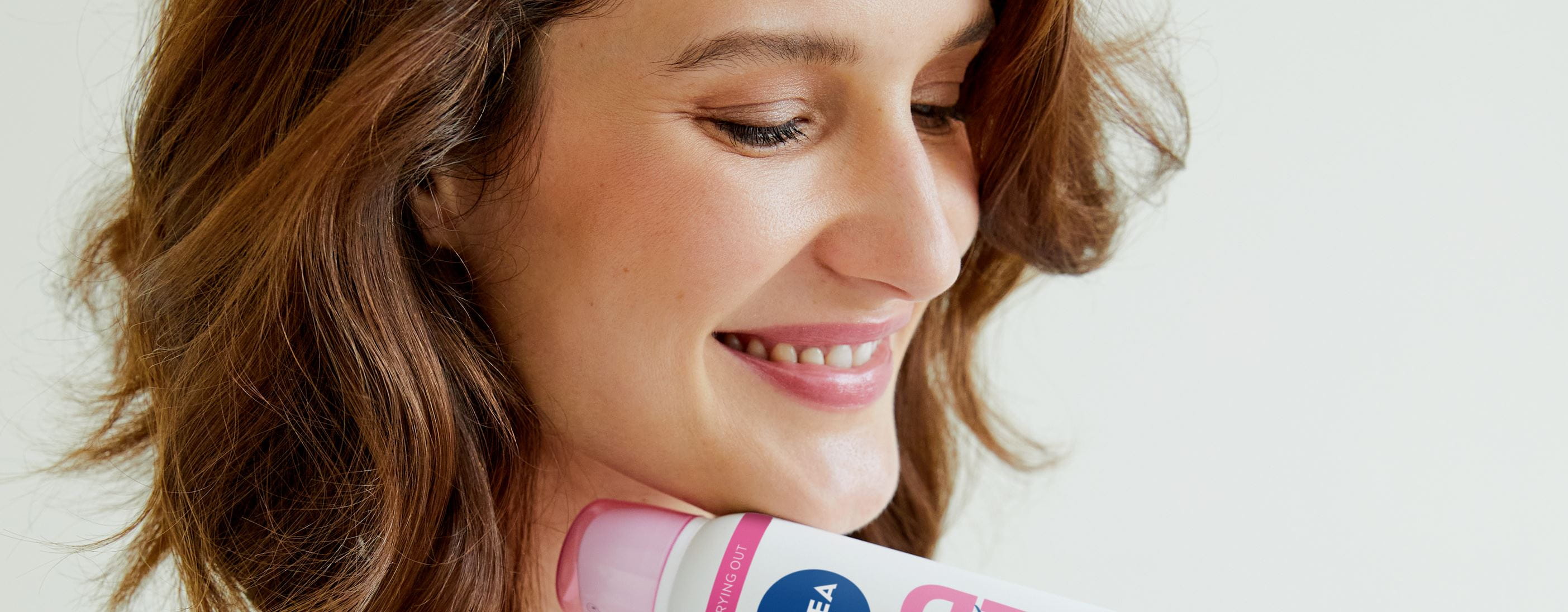 Junge Frau benutzt Trockenshampoo von Nivea