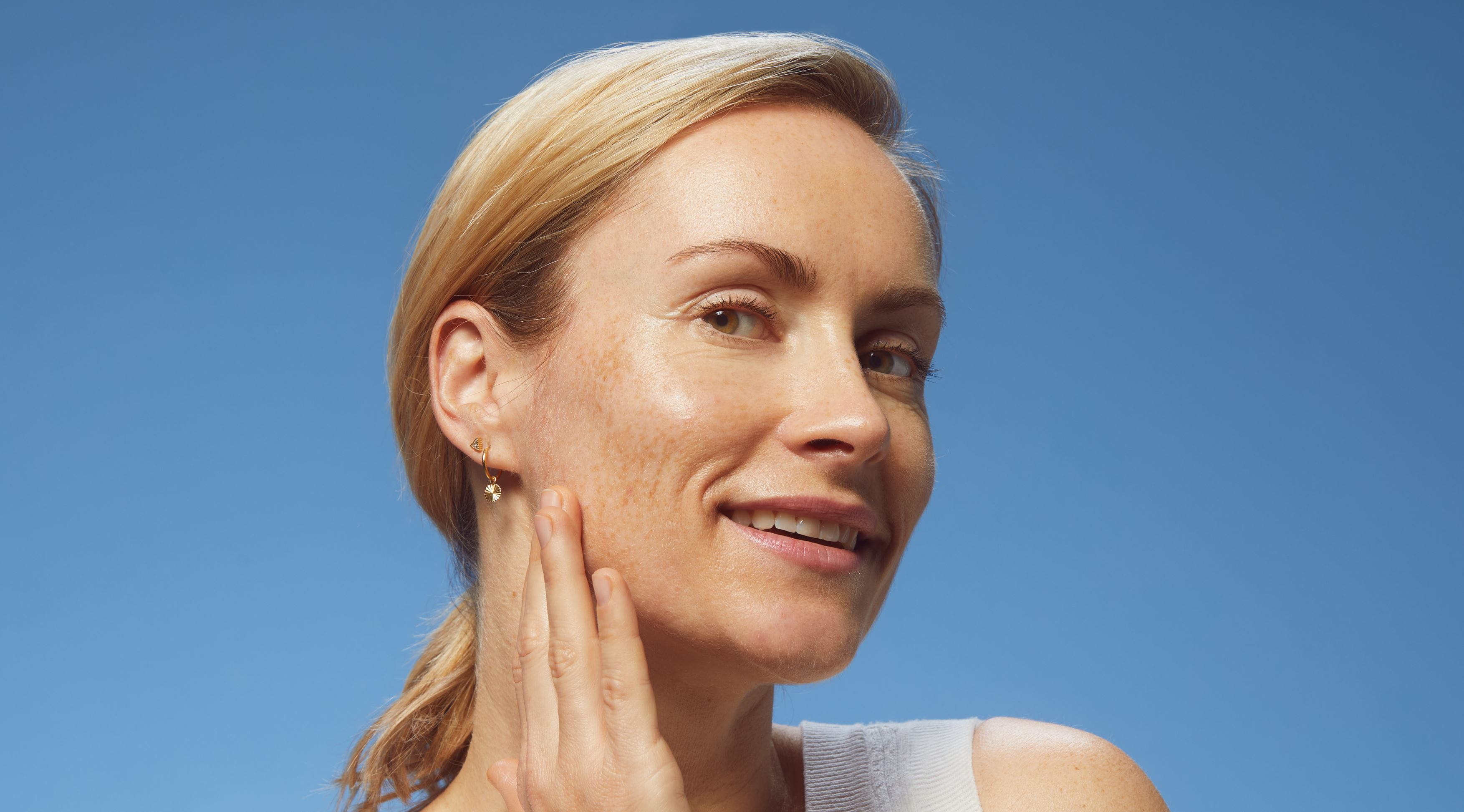 blonde hair woman touching her face