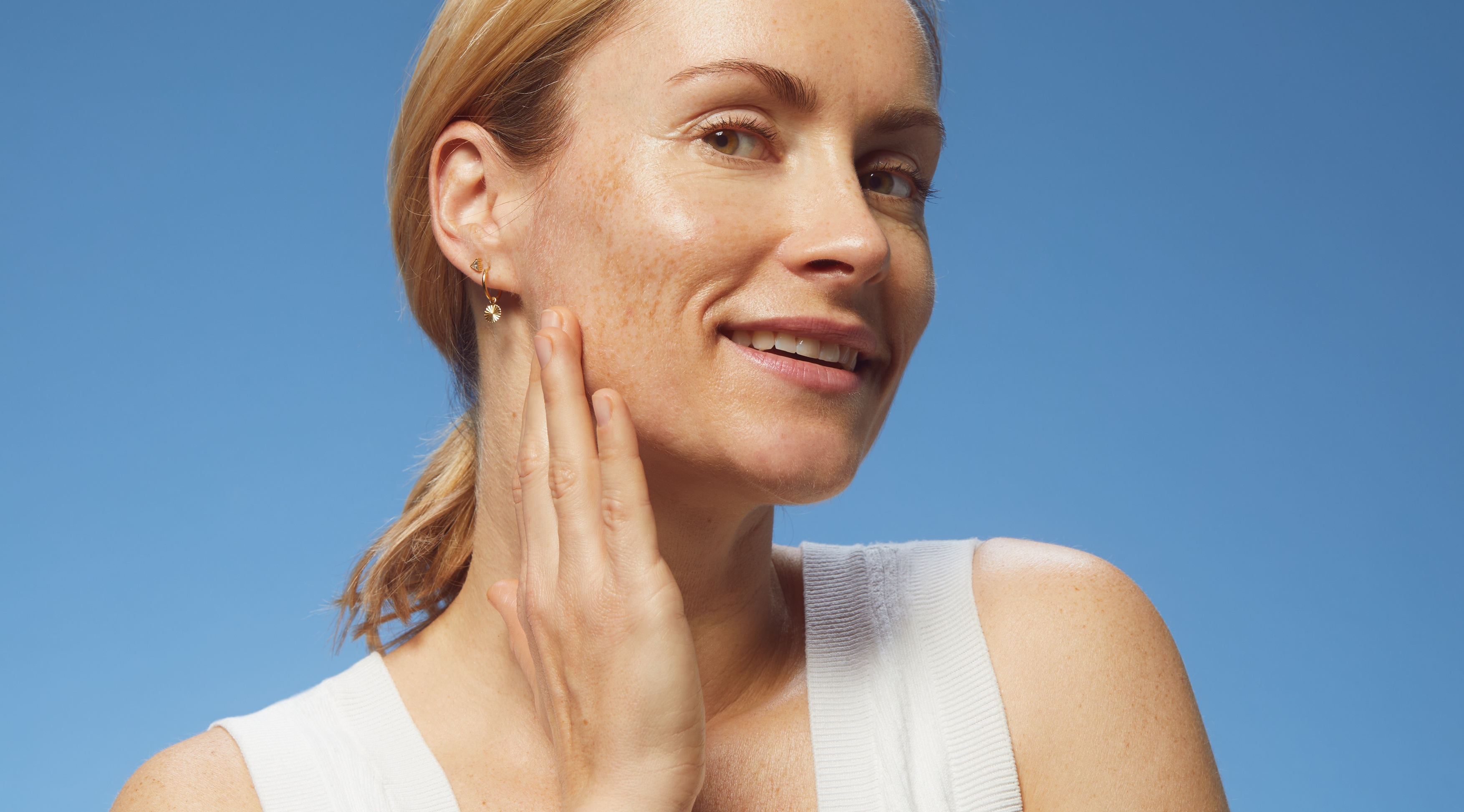 blonde hair woman touching her face