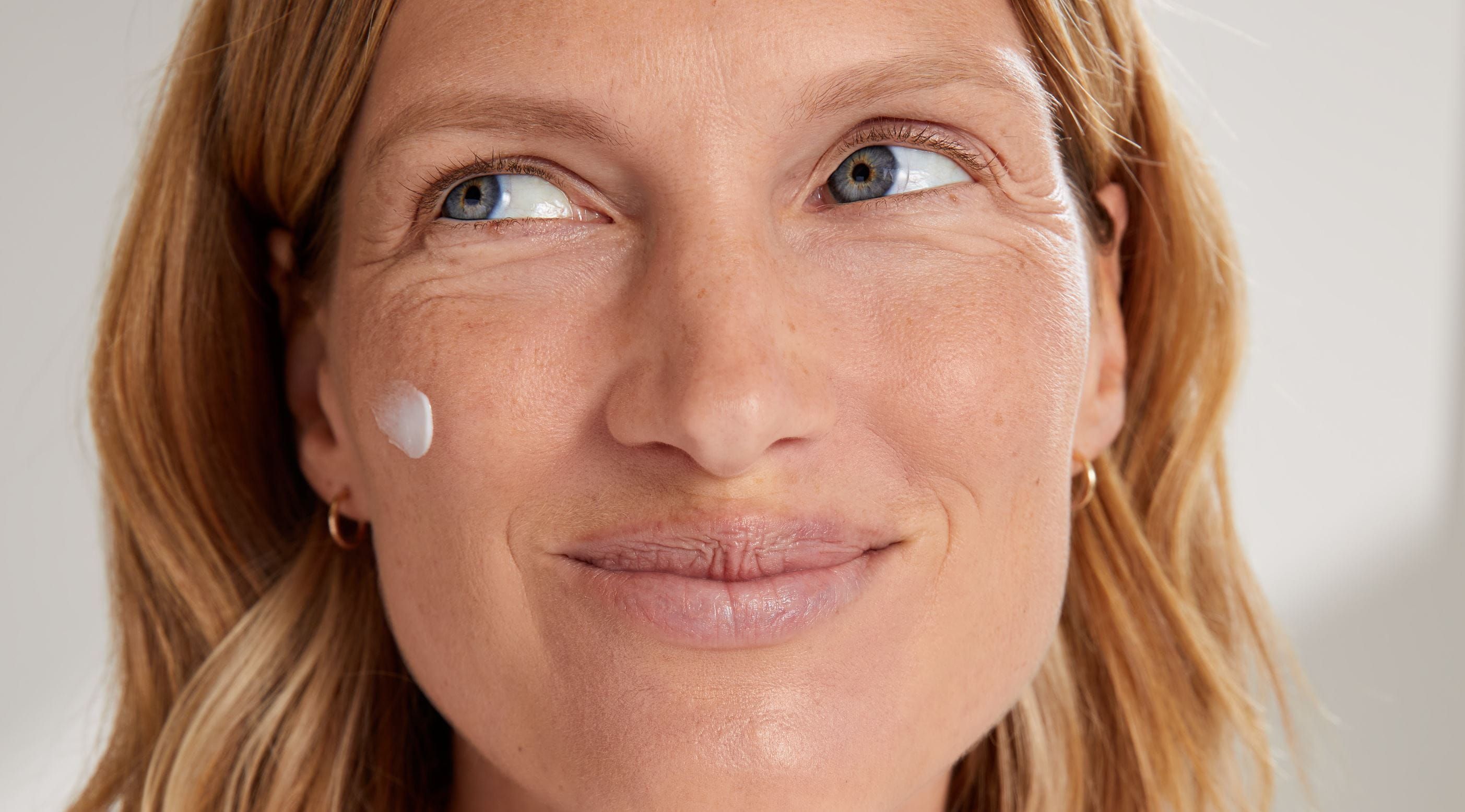 Frau mit Nivea Q10-Creme im Gesicht