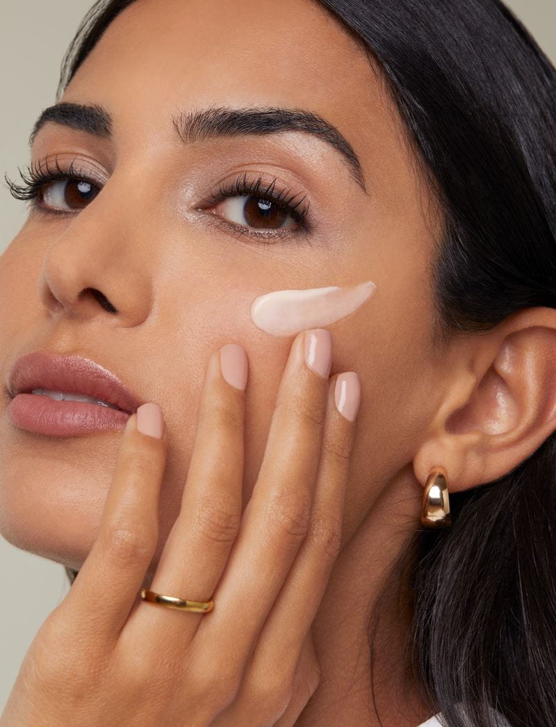mulher aplicando creme facial