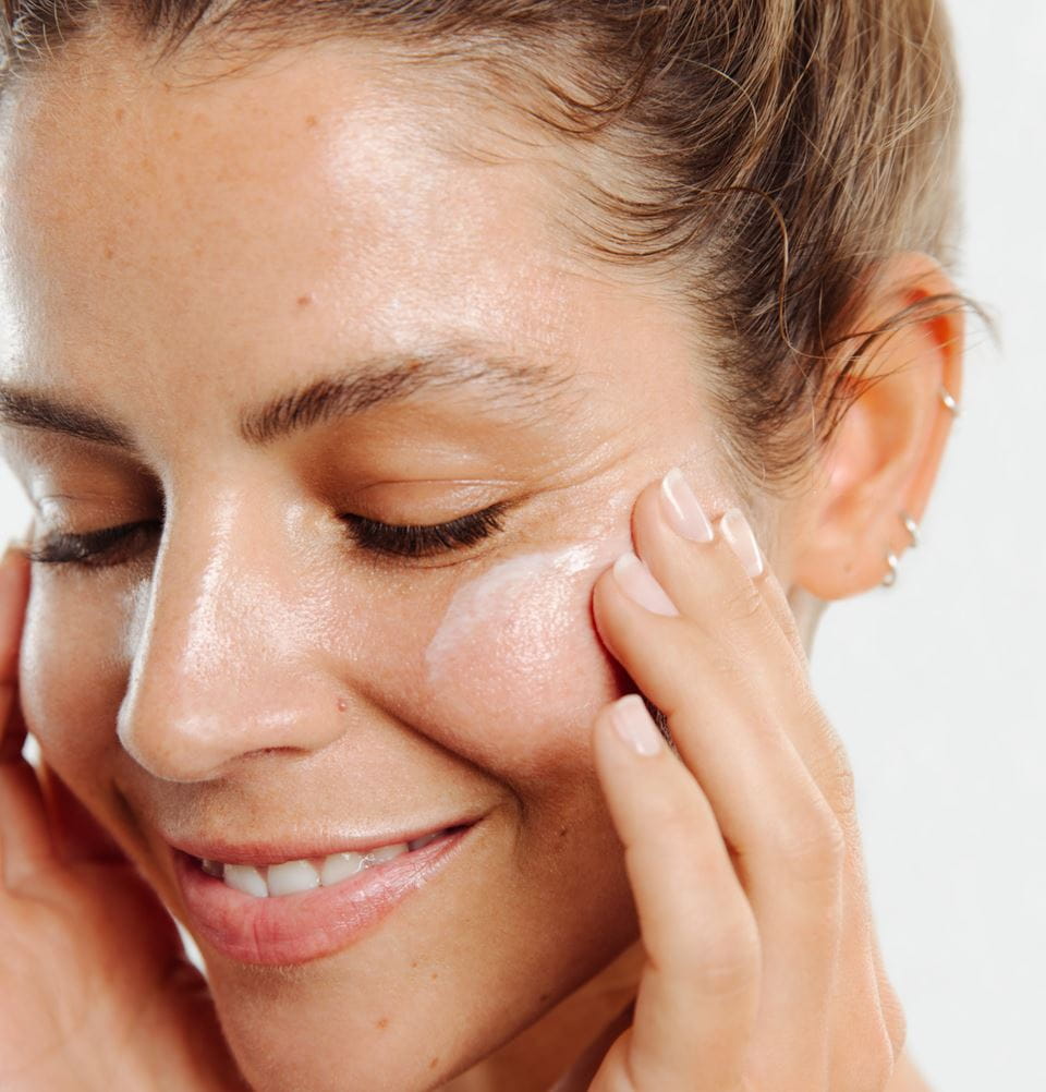 Frau, die ihr Gesicht reinigt