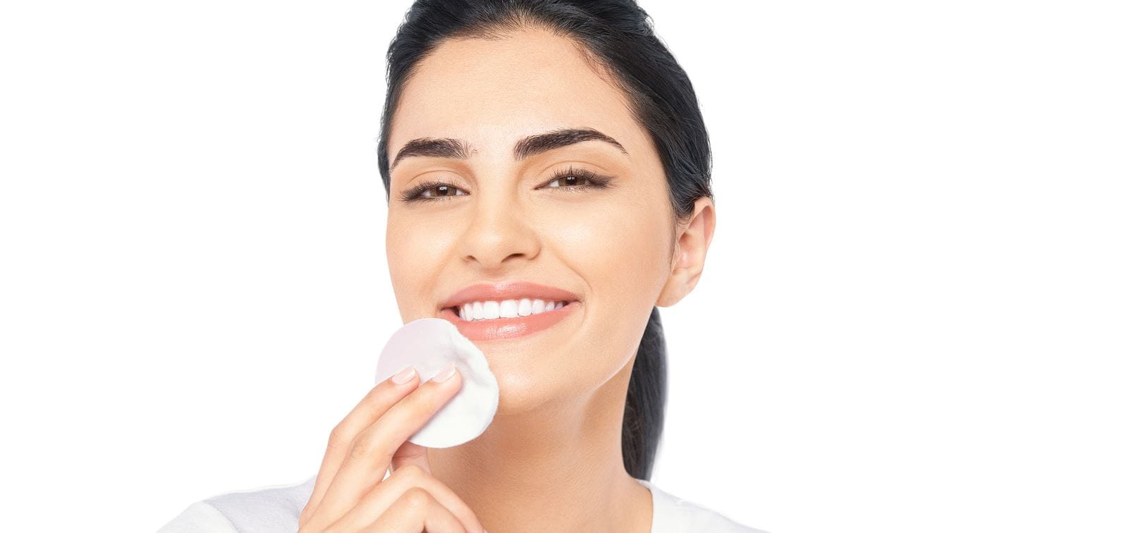 Frau, die ihr Gesicht mit einem Wattepad reinigt