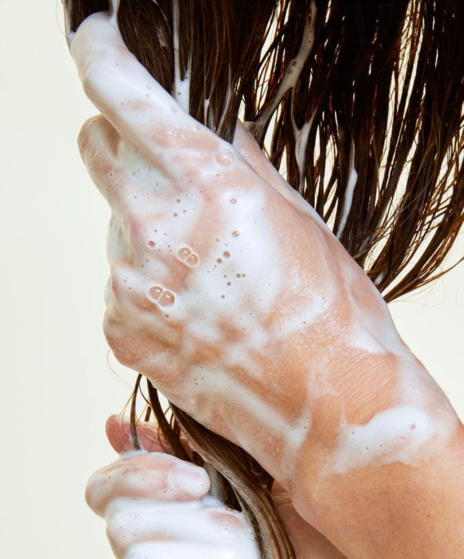 Frau wäscht sich die Haare