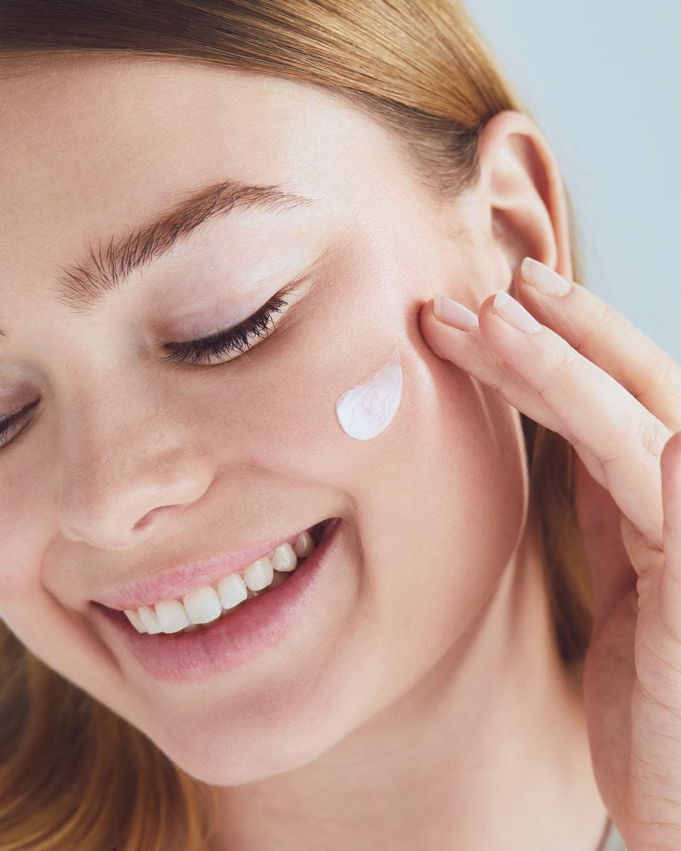  jonge vrouw die Nivea-gezichtscrème aanbrengt