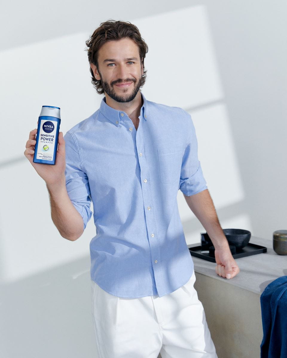 junger Mann, der Nivea Sensitive Power Shampoo verwendet