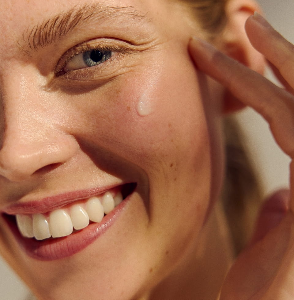 mulher segurando um creme facial antirrugas Nivea Q10