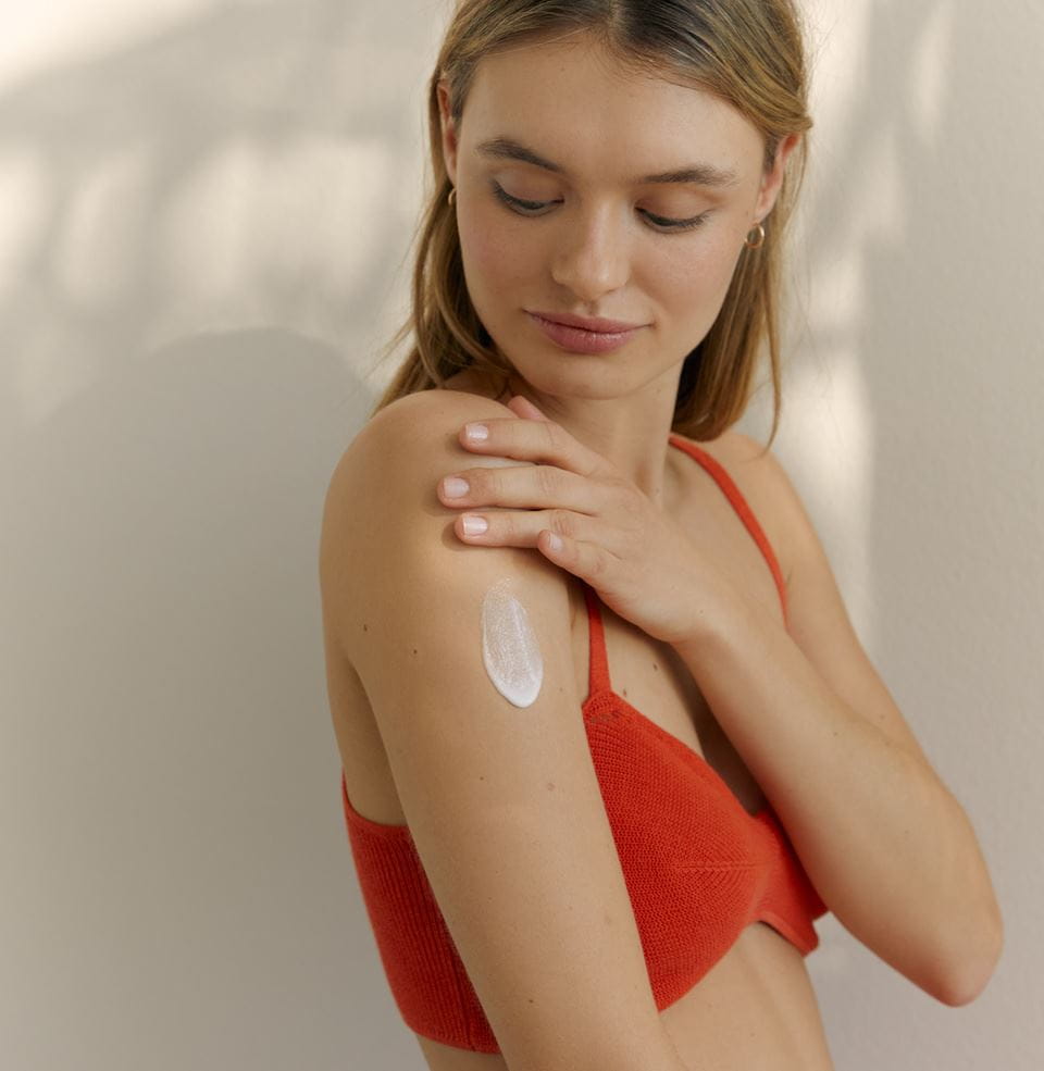 Junge Frau trägt Nivea-Selbstbräunungs-Körperlotion auf