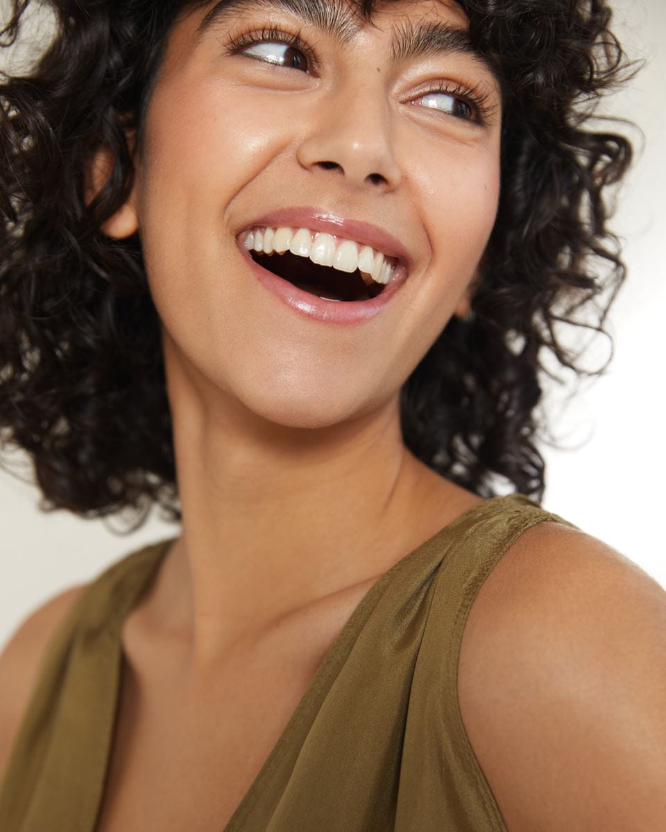 femme aux cheveux bouclés courts souriant