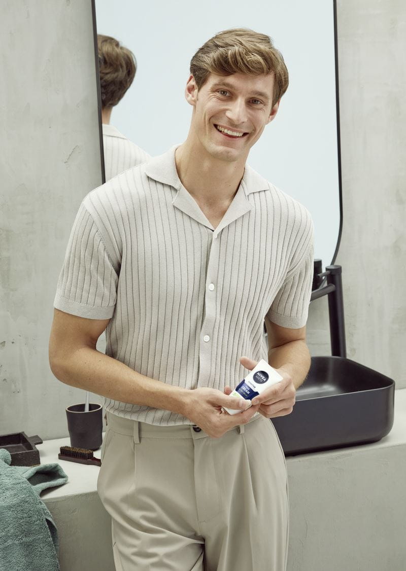 Junger Mann verwendet Nivea-Gesichtscreme