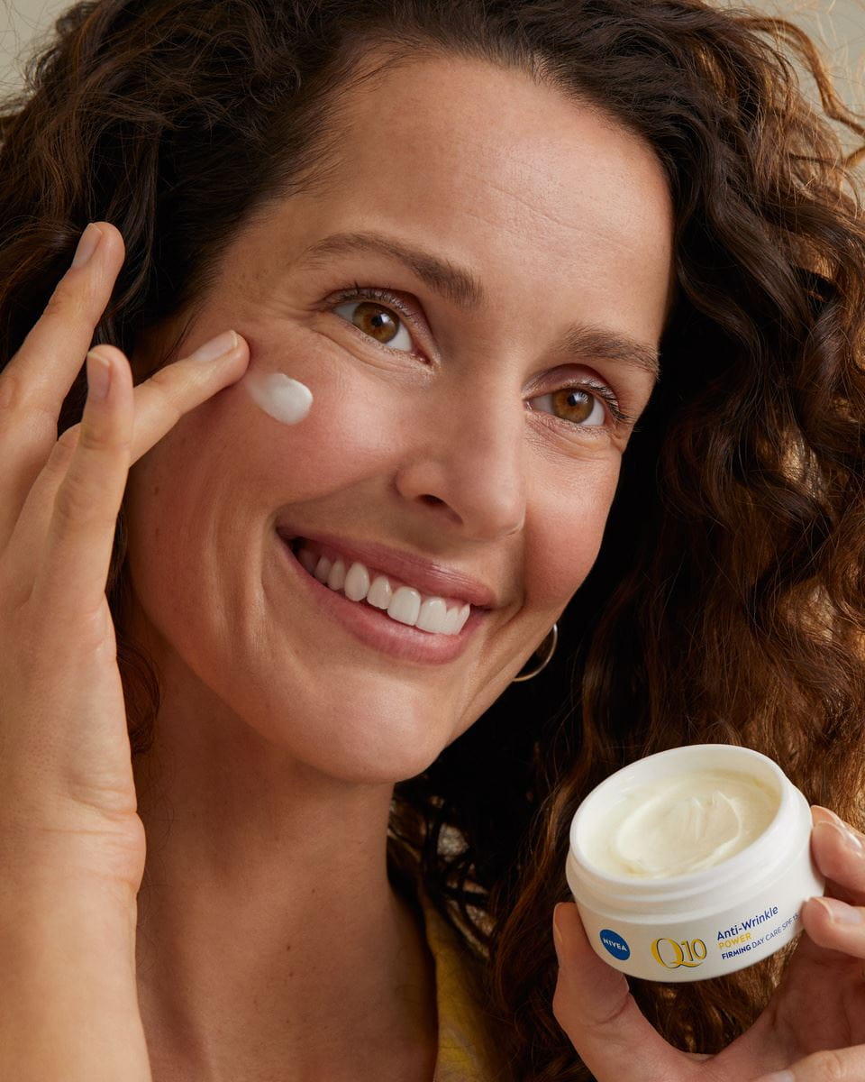 donna che applica la crema viso Nivea Q10