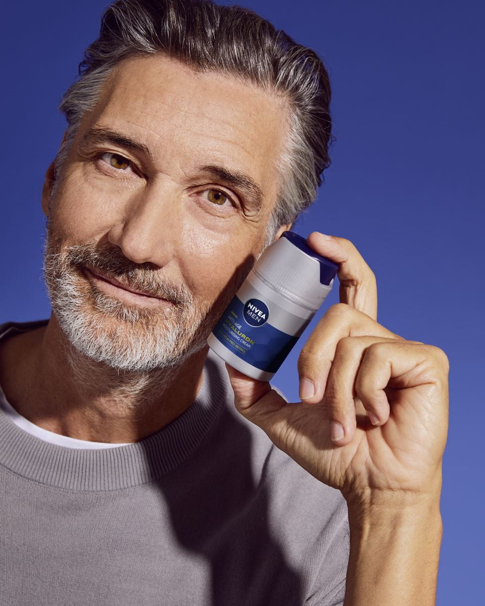 mężczyzna stosujący żel nawilżający do twarzy Nivea Anti-age Hyaluron