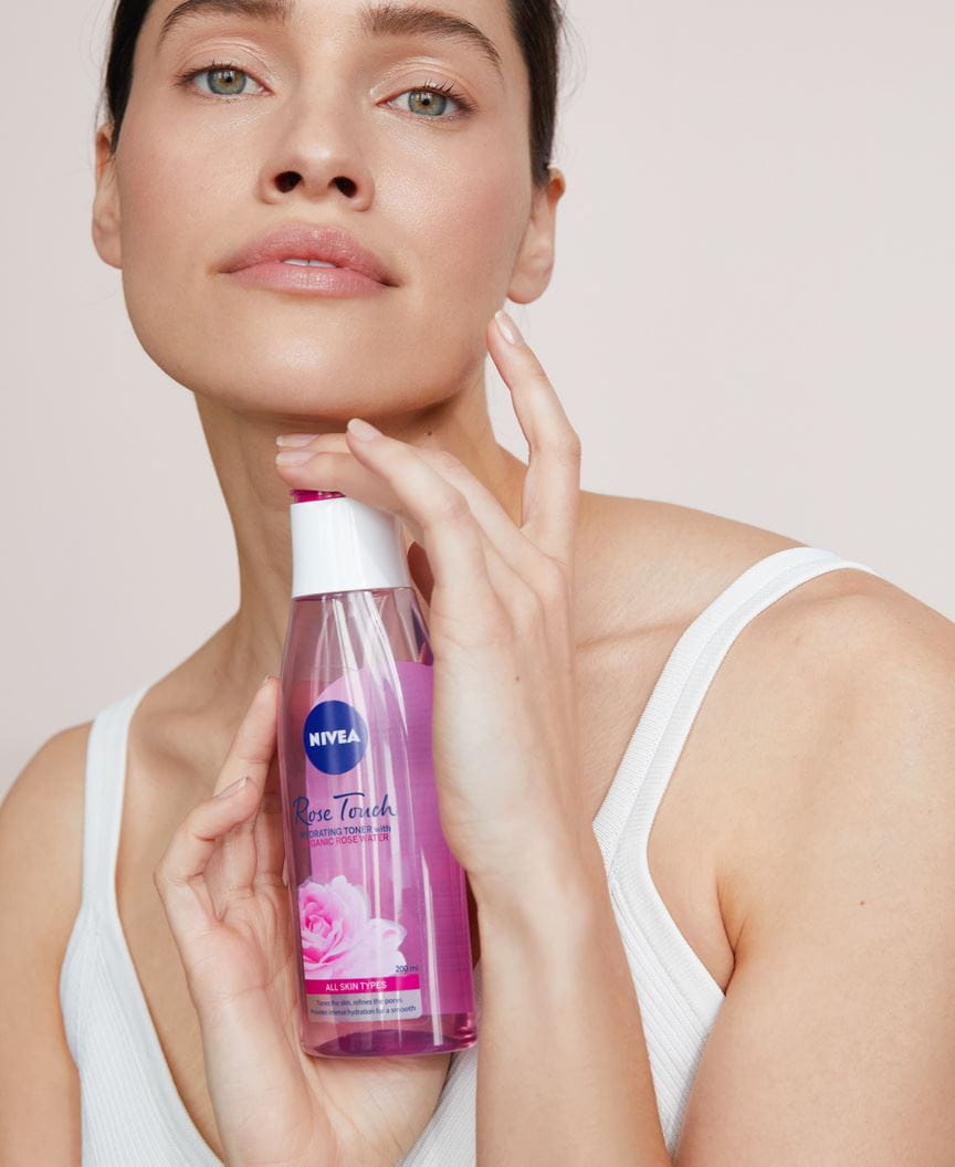 kobieta trzyma nawilżający tonik Nivea Rose Touch