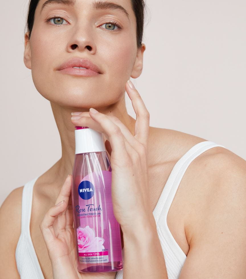 Frau hält einen Nivea Rose Touch Hydrating Toner in der Hand