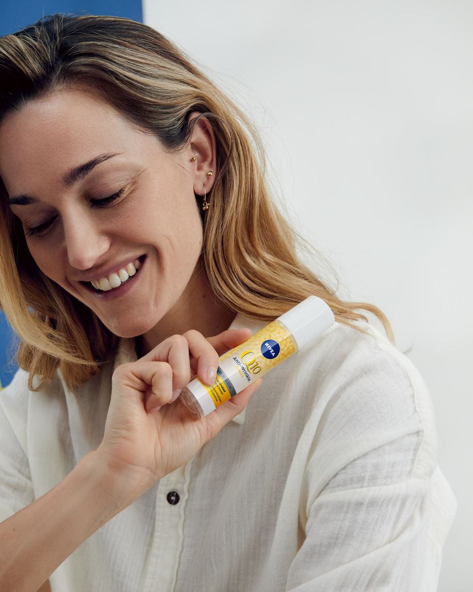 woman holding a Nivea Q10 Anti-Wrinkle power Replenishing Serum Pearl 
