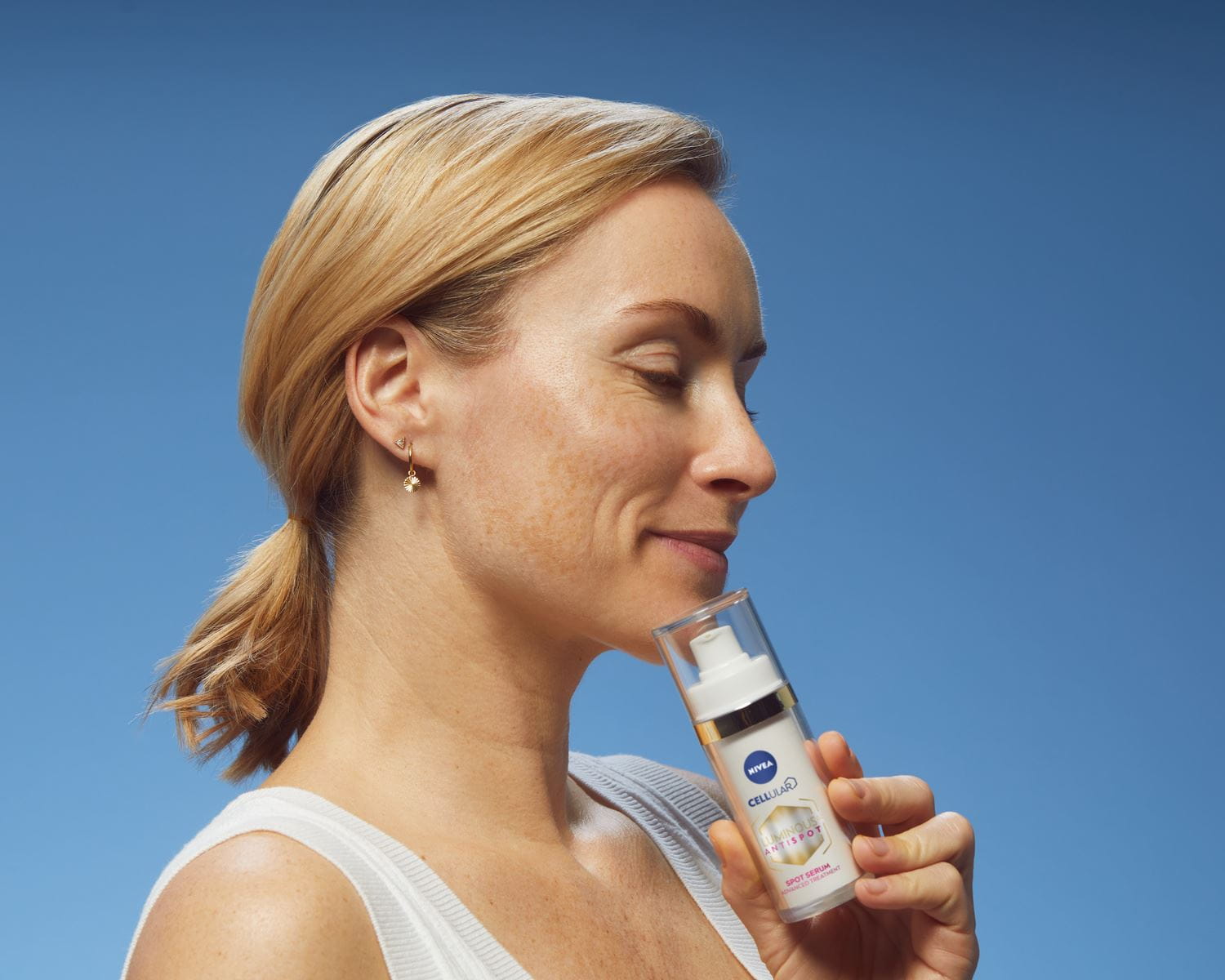 Mujer rubia usando NIVEA Cellular Luminous630 Anti Dark-Spot Face Treatment Serum