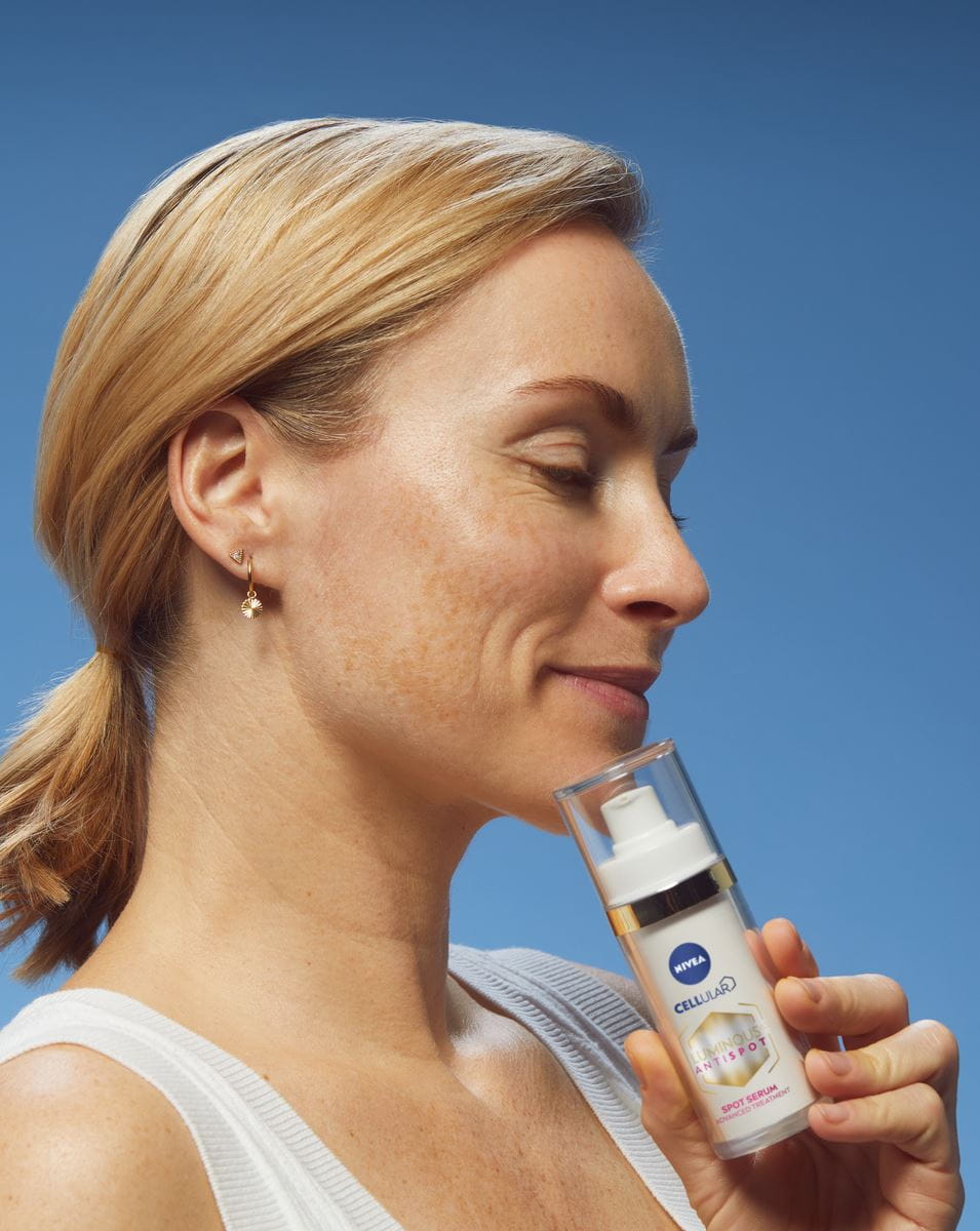 Blonde Frau verwendet NIVEA Cellular Luminous630 Anti Dark-Spot Gesichtsbehandlungsserum