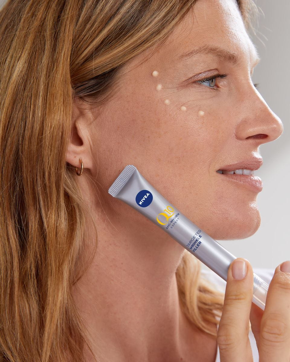 Frau, die Nivea Q10 Fillerserum verwendet