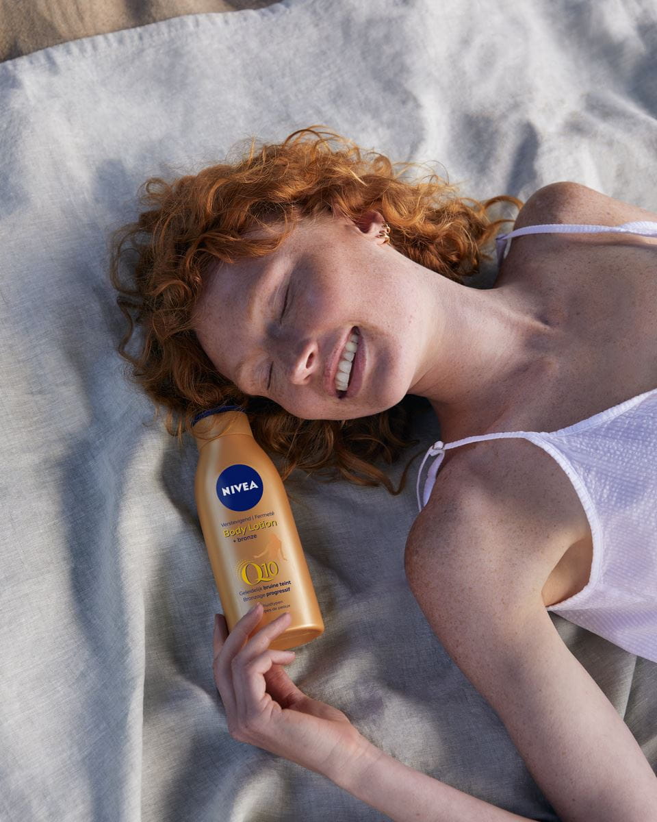 tânără care folosește loțiune Nivea self tab