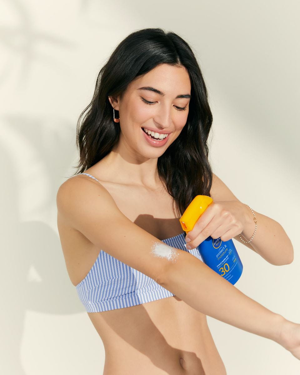  Frau, die Nivea SPF-Spray aufträgt