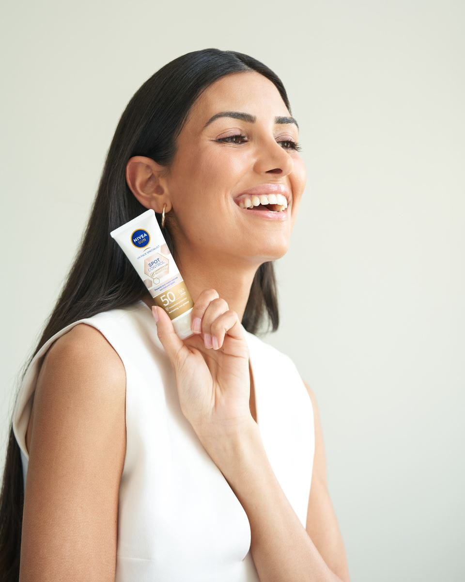 ung kvinne som bruker Nivea Sun Spot Control ansiktskrem