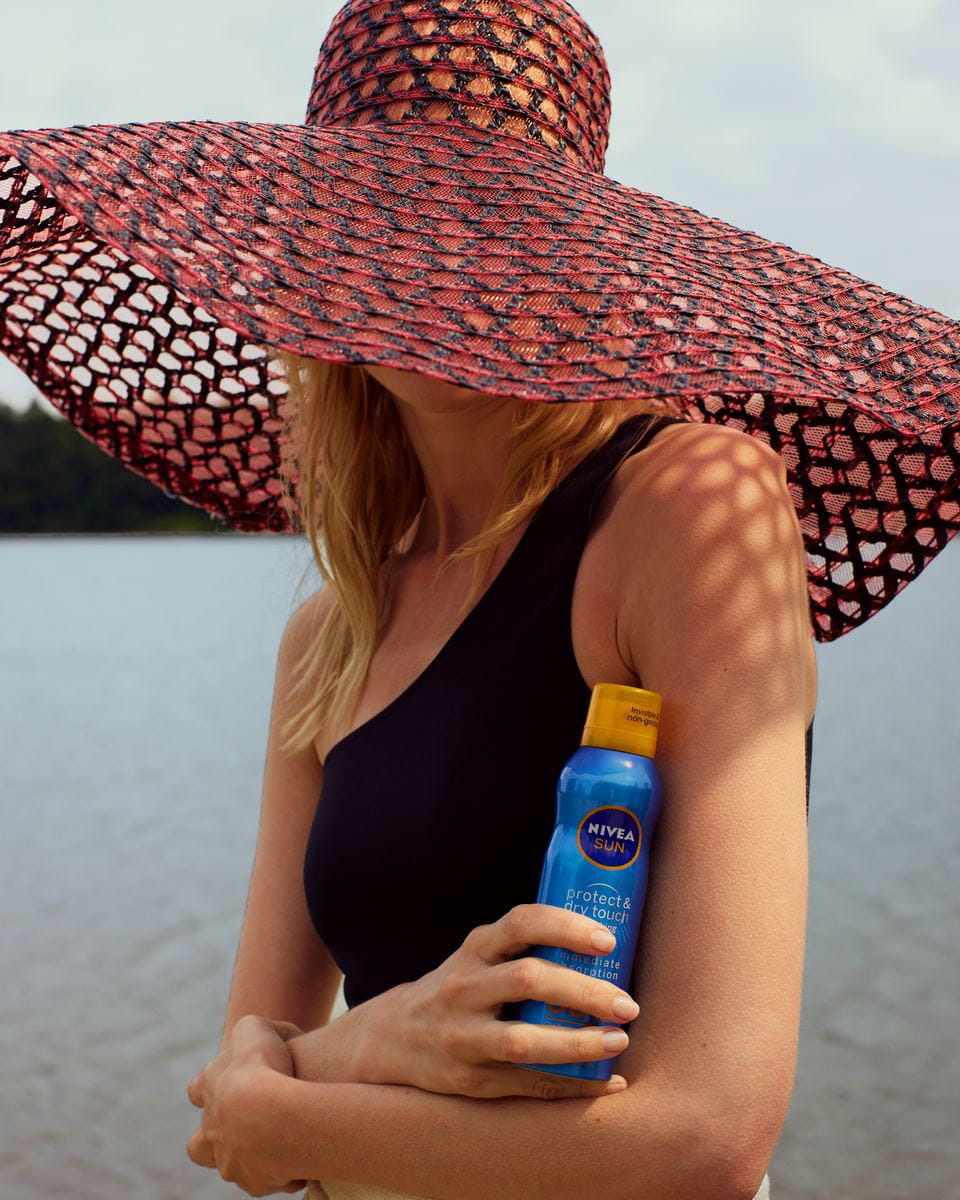 woman holding nivea face sunscreen