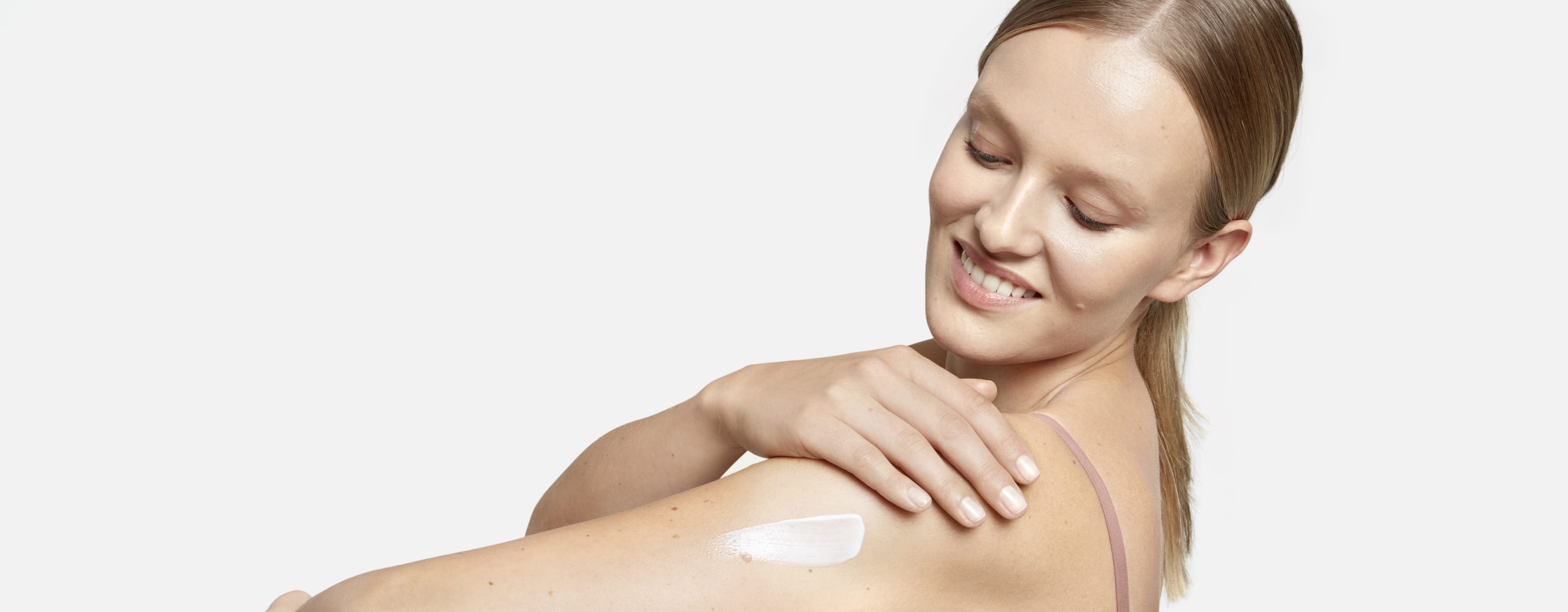 Women applying skin cream on her arm