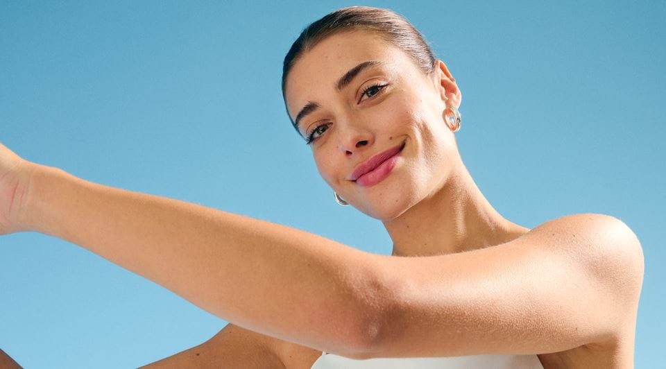 Woman with white shirt smiling under the blue sky