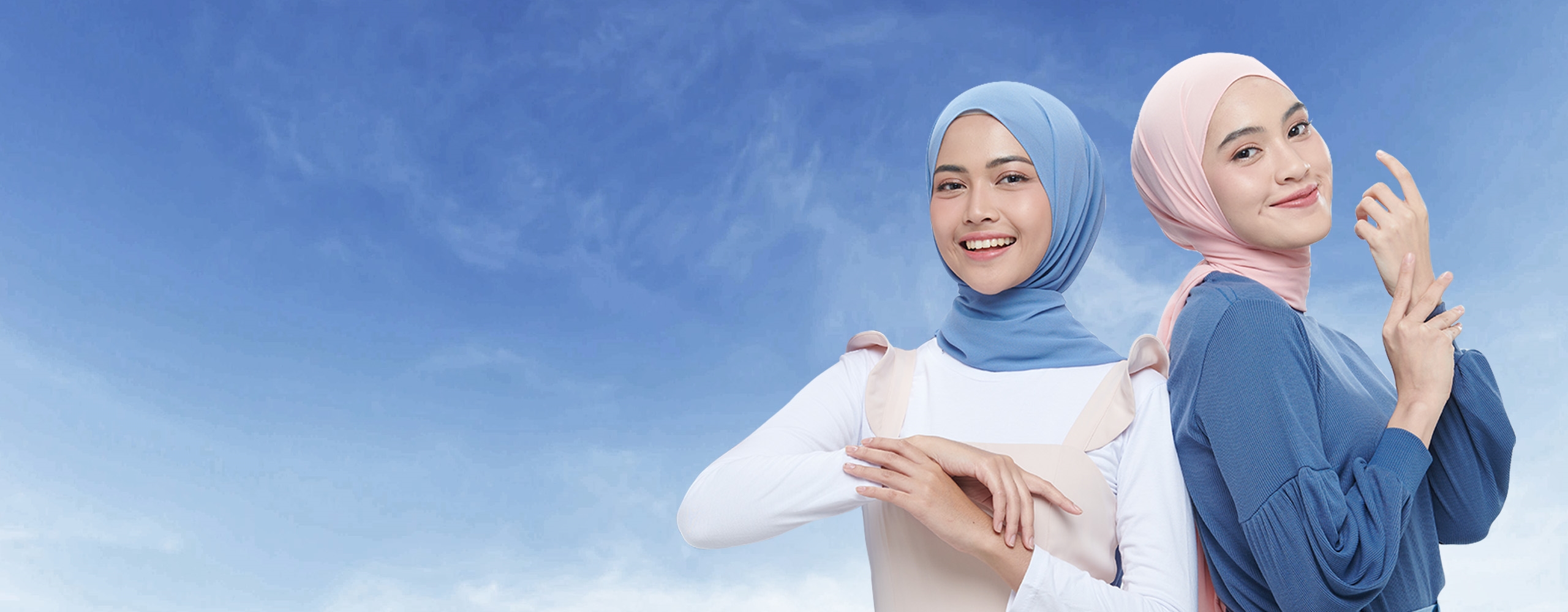 Two smiling women wearing hijabs