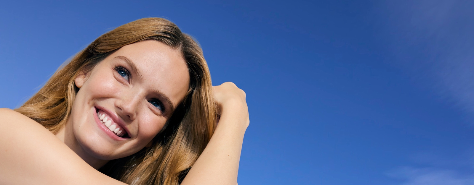 Smiling girl under blue sky