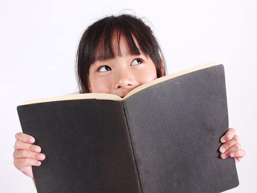 little girl holding a black book