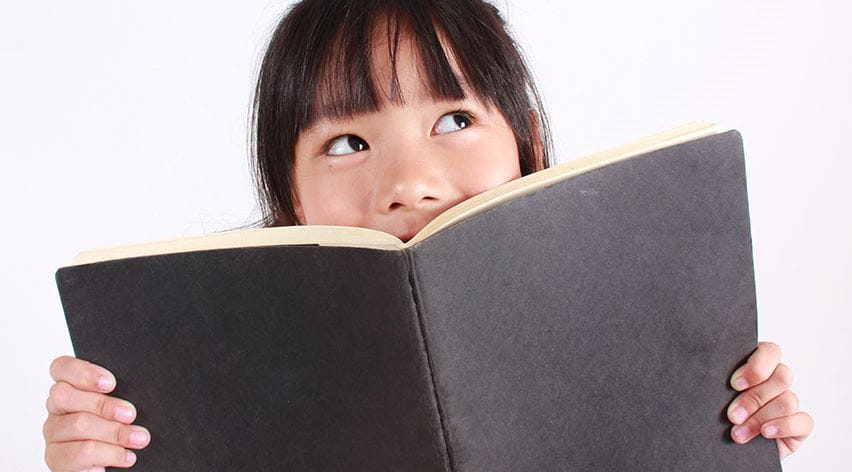 little girl holding a black book