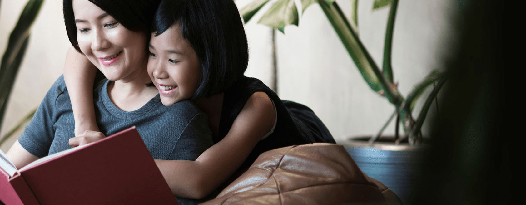 mom and daughter reading a red book