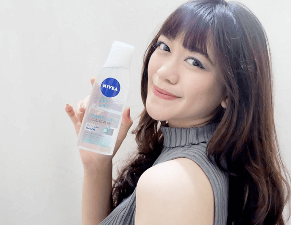 woman with bangs holding NIVEA products