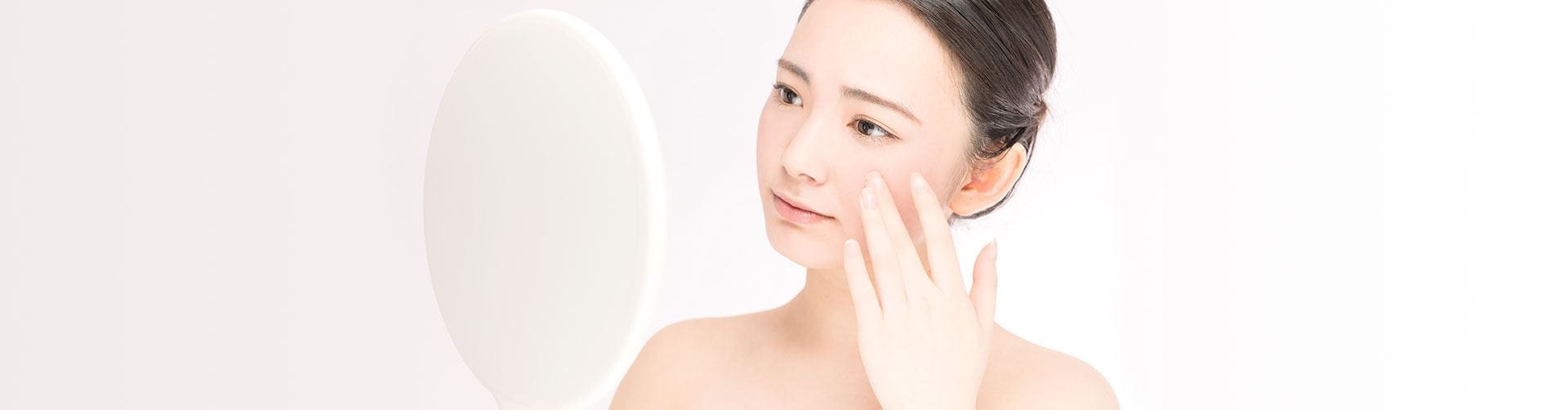 woman seeing her face in the mirror and touching it