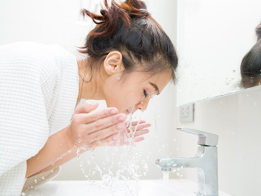 woman splashing her face with water