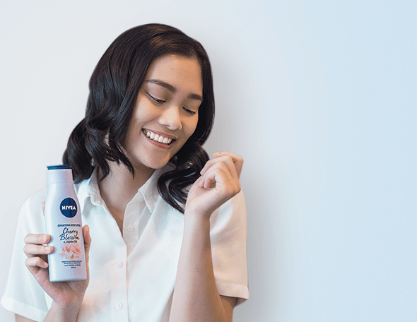 woman holding NIVEA Body Lotion Cherry Blossom