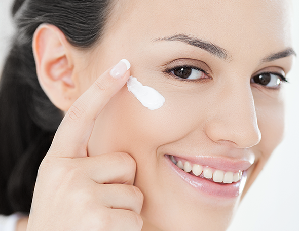 woman applying cream on her face